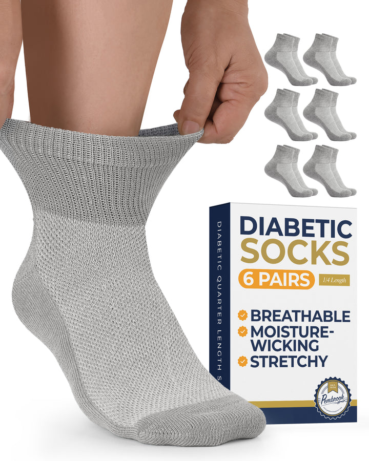 Gray diabetic sock being worn with a box of six pairs of diabetic socks in the background.