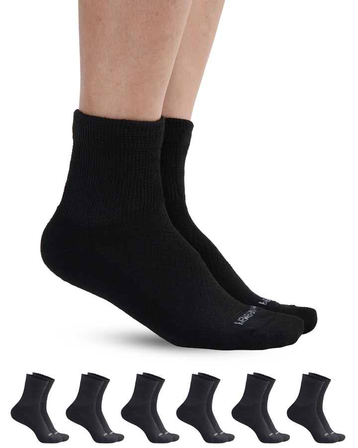 Black socks being worn with a set of six additional black socks displayed below on a white background.